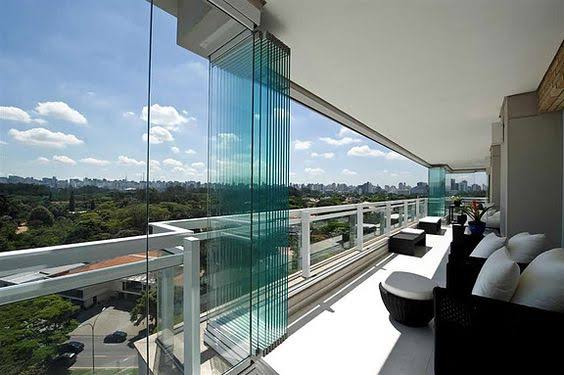 Sacada com painéis de vidro recolhíveis e vista aberta